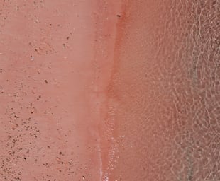 a person standing on a beach with a surfboard