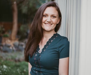 a woman in a green dress smiling and looking at the camera