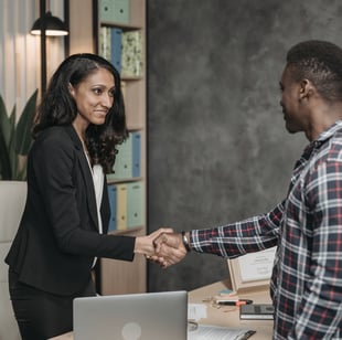 a man and woman shaking hands in a meeting room