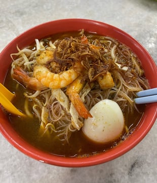 prawn noodles in a flavorful broth with an egg
