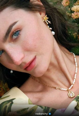 a woman with a pearl necklace and pearl earrings