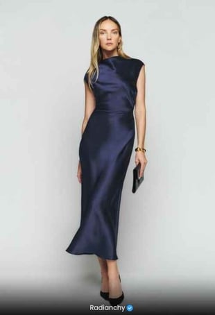 a woman in a blue dress with a clutch bag