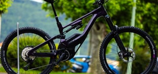Vélo electrique lapierre noir tout suspendu pris en photo proche du magasin