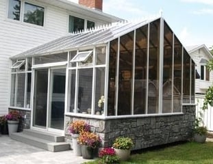 Gable Solarium or Peaked Solarium with faux stone pony wall, roof crests and sliding door.