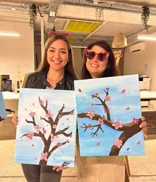 Participants fières de leurs œuvres après un atelier peinture EVJF