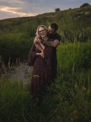 a man and woman standing in a field for a photoshoot in Calgary 