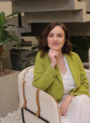 Contemplative mentor in green blazer, seated with grace
