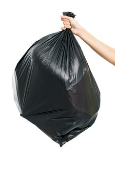 a person holding a black bag of garbage bags