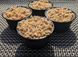 Lemon and ginger meringue ice cream in pots, topped with a rhubarb crumble