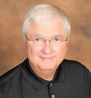 white haired man in a black shirt and glasses