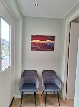 2 stoelen in een kamer met een schilderij aan de muur