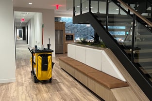 A janitor's cart inside the kitchen area of an office building.