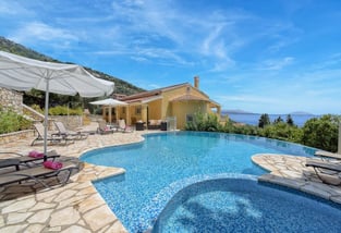 Private villa with private swimming pool with ocean and hills in the background