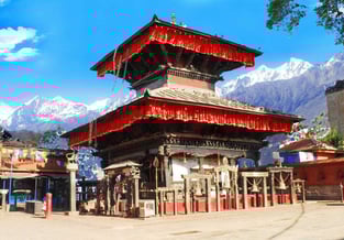 a temple with a red roof surrounded by snow mountains