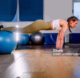 a woman doing push ups on a ball