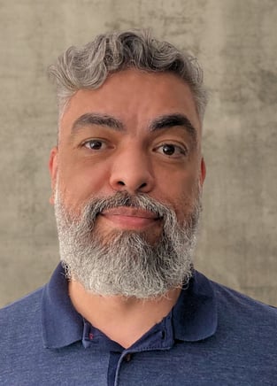 Cesar Felicio - Foto de perfil sobre um fundo acinzentado 