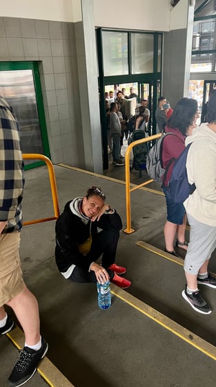 a woman sitting on the ground waiting for the cable car