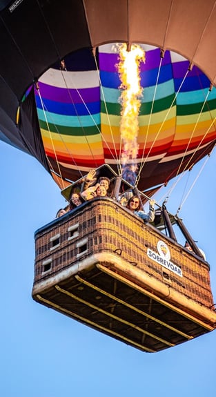 Voo de balão compartilhado repleto de família feliz sobrevoando Praia Grande-SC