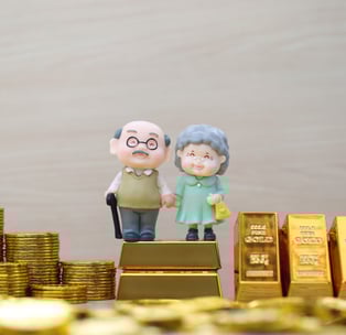 elderly couple with gold bars and coins for retirement