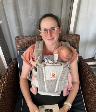 Mom wearing her newborn in an Ergo baby carrier.
