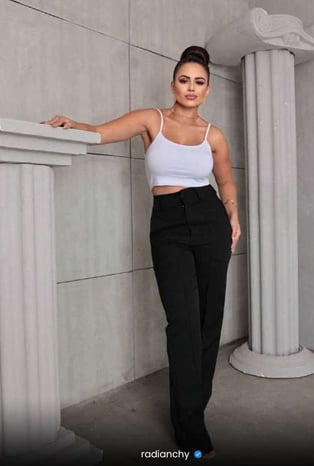 a woman in a white crop top and black pants