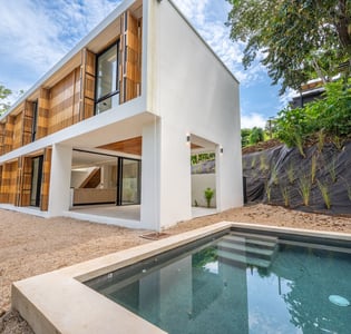 A house with a pool and a pool in the back in Tamarindo
