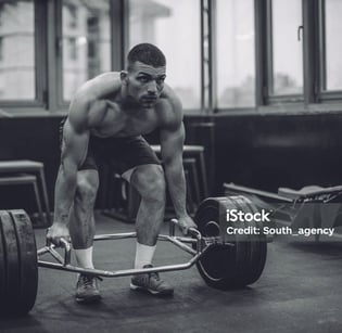 a man is squatting on a barbell