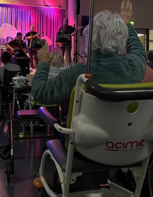 Photo de Magali STrassel, art-thérapeute, montrant une personne agée apprécier un concert