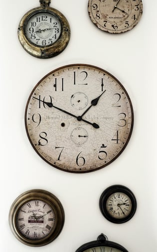 plusieurs vieilles horloges accrochées sur un mur et donnant des heures différenes. Unsplash.