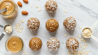 No-bake protein energy balls with shredded coconut, surrounded by oats, almonds, and peanut butter.