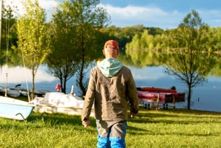 a man walking through a field with boats and boats