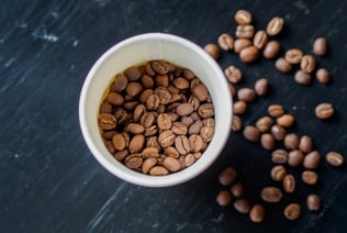 a cup of coffee beans and coffee beans