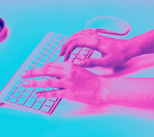 a person's hands typing on a keyboard