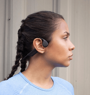 a woman with a blue shirt and earphones on
