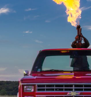 Lance-flamme dans un Pick-up rouge Chevrolet C10 dans un champ