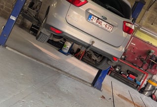 a car is parked in a garage with a car underneath it