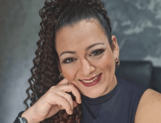 a woman with curly hair and a watch on her phone