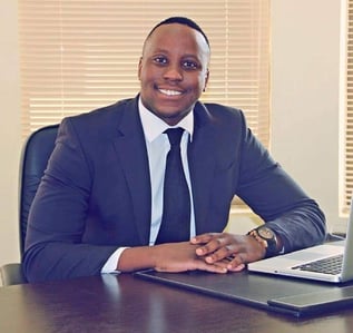 a man in a suit and tie sitting at a desk