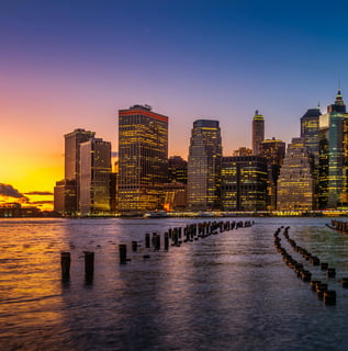 a city skyline with a sunset over the water