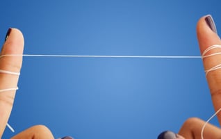 a person's fingers wrapped with a string of dental floss