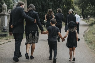 a group of people dressed in black clothing, walking into a church.