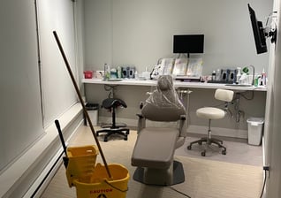 a dental office room with a mop and a bucket.