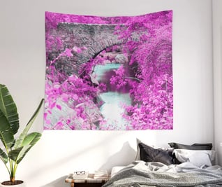 Wall tapestry of fantasy bridge hanging on wall with bed underneath this.