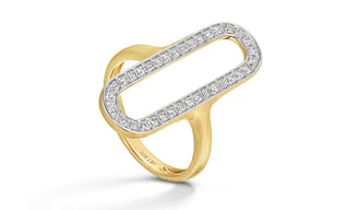 Modern gold ring with open oval shape, outlined in white metal and encrusted with diamonds, on white background