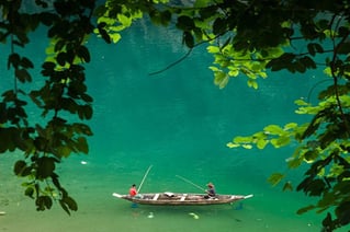 a man fishing in a lake with a boat