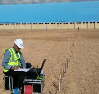 a man in a hard hat and a laptop computer