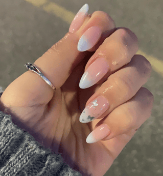 ombre baby blue manicure with sparkle butterfly accent nail on ring finger