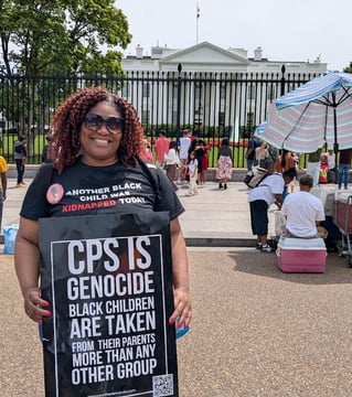 Lucky in front of White House wearing Black Mothers March shirt & holding a "CPS is Genocide" sign. 