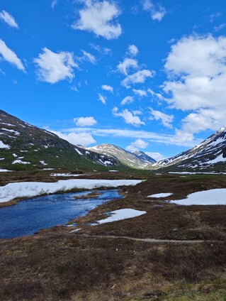 Snow scattered on top of mountains with lake