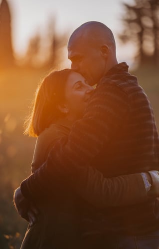 uomo-e-donna-che-si-baciano-al-tramonto